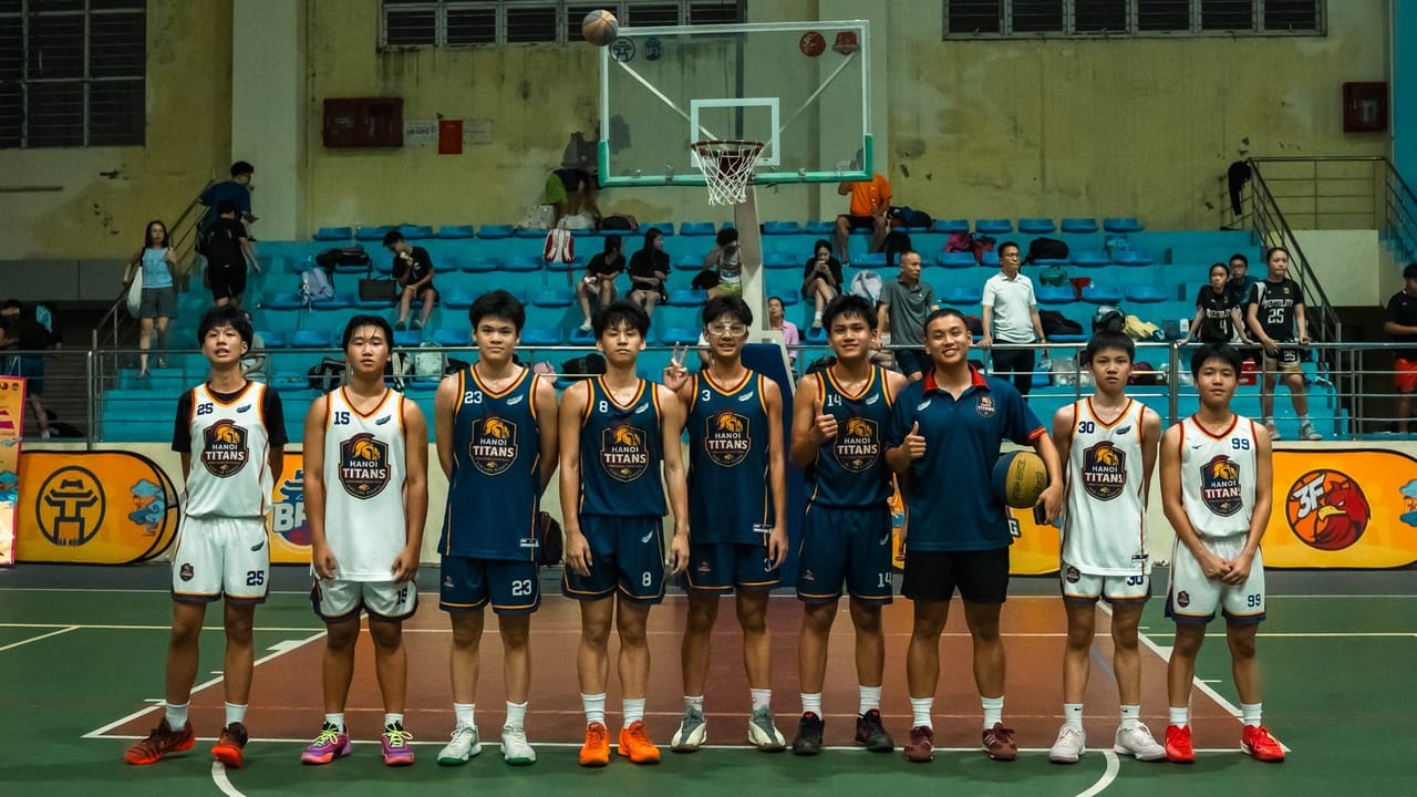 Các cầu thủ U15 Hanoi Titans và huấn luyện viên đứng thành hàng trên sân thi đấu