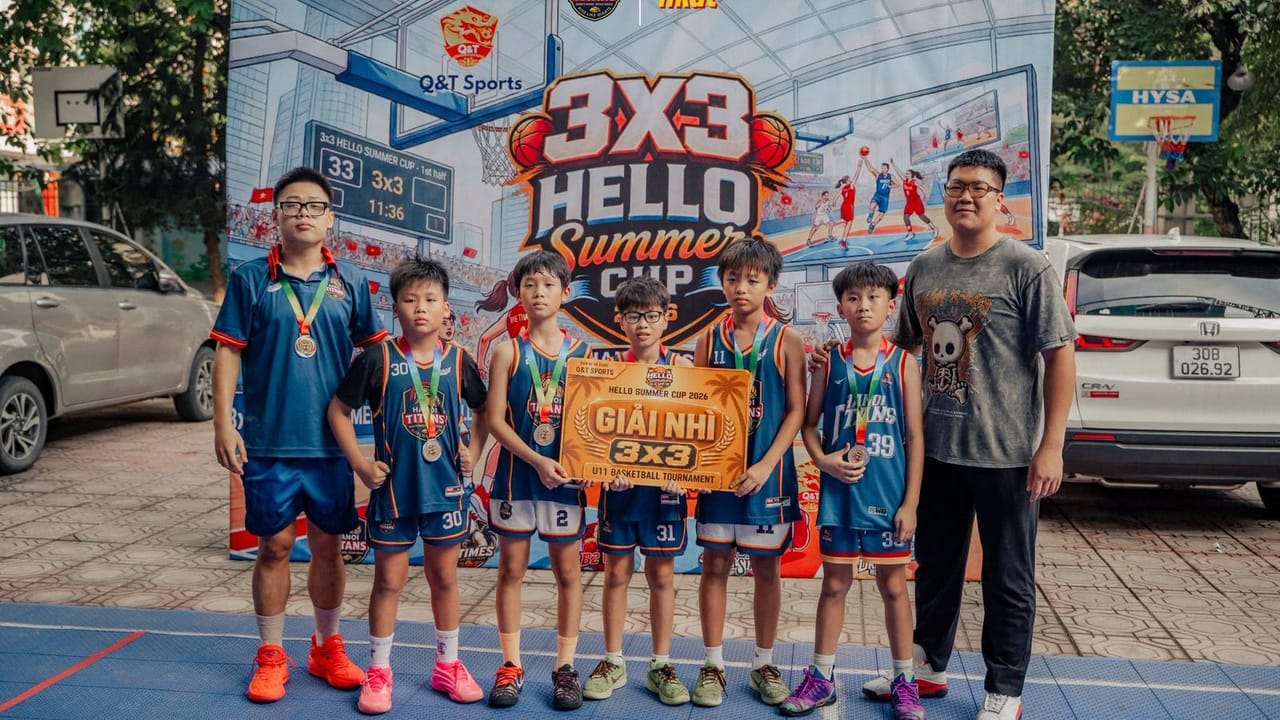 Các cầu thủ Hanoi Titans đeo huy chương cầm băng rôn Giải Nhì 3x3 đứng cùng hai người lớn trước phông giải Hello Summer