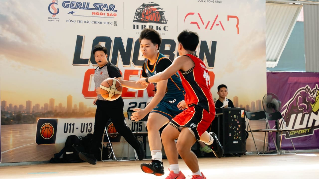 Cầu thủ Hanoi Titans dẫn bóng qua đối thủ áo đỏ trước phông Long Biên Open Cup