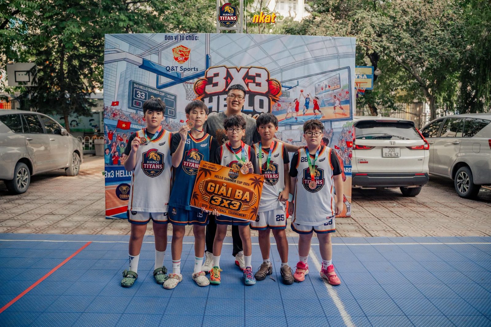 Các cầu thủ Hanoi Titans đeo huy chương cầm băng rôn Giải Ba 3x3 trước phông giải đấu